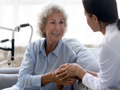Picture of a female doctor speaking with a female elderly patient in an office setting.